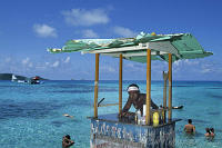 Bahamas, Bimini, Young man at bar in sea. Background Catalina PBY-5A hydroplane. Peter Stuyvesant Travel Odyssey 1993/1994.